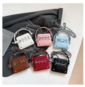 Flat lay of mini rivet crossbody bags in six colors with chain straps and litchi texture