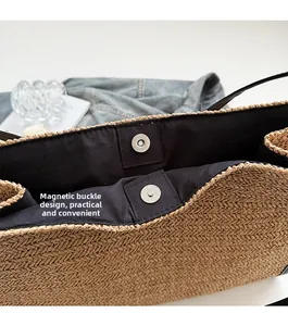 Detail view of woven straw tote bag featuring practical dual magnetic snap button closure