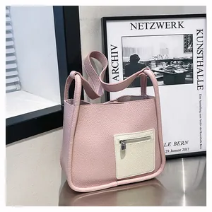 Detailed macro view of the pink lychee leather texture and front pocket on the bucket bag