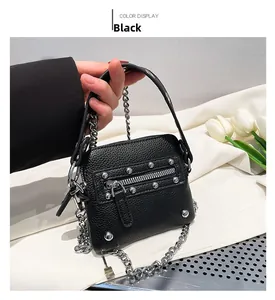 Detail of black pebbled leather mini bag with silver rivets and chunky metal chain