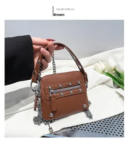 Detailed close-up of brown studded mini bag with silver chain strap and litchi texture