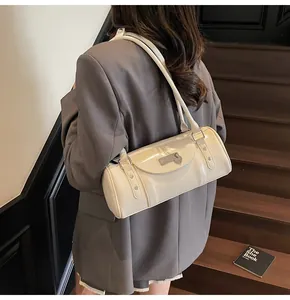 Détail du sac cylindrique crème fini brillant avec décoration en métal en cœur