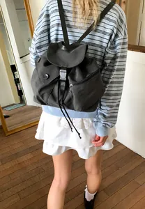 Detail of dark grey nylon backpack featuring water-resistant fabric and plastic buckle closure