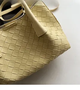 Vue détaillée du tissage en cuir jaune et des coutures de l'anse du sac seau