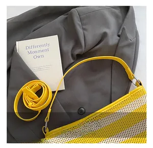 Close-up of yellow striped woven tote bag with adjustable straps on a gray blazer