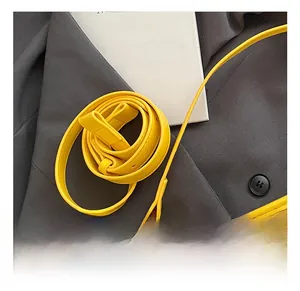 Detail of adjustable PU leather strap and yellow knit texture on the bucket bag