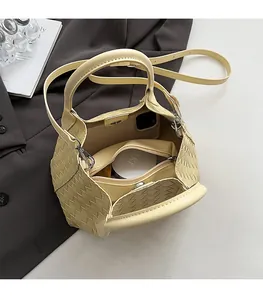 Vue intérieure montrant la grande capacité et les poches du sac à main en cuir tressé jaune