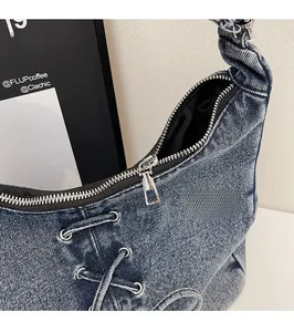 Détail de la fermeture éclair en métal argenté et du laçage sur le sac fourre-tout bleu