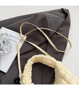 Detail of cream quilted cloud bag with adjustable strap and puffy texture on blazer