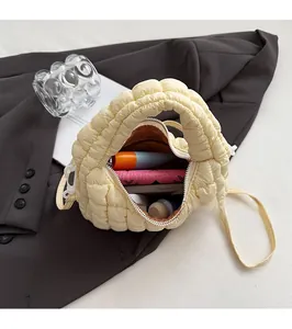 Detail of yellow quilted puffer bag capacity showing essentials and nylon texture