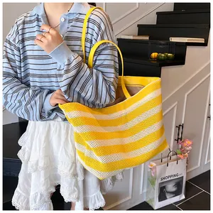 Grand sac cabas tissé à rayures jaunes avec lanières en cuir porté par un mannequin