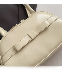 Detail of cream PU leather handbag showing refined stitching and sleek texture