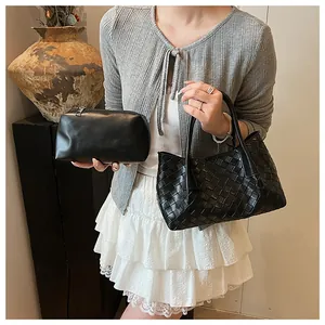 Détail du cabas tissé noir et de sa pochette assortie avec texture de qualité