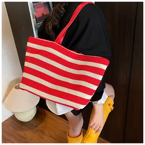 Détail du grand sac cabas tissé à rayures rouges et blanches avec anses en cuir