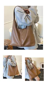 Close-up of brown pebbled leather texture and integrated strap on spacious tote bag