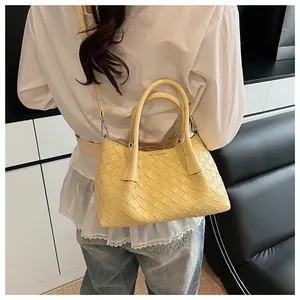 Détail du sac cabas jaune tressé avec doubles poignées et bandoulière amovible