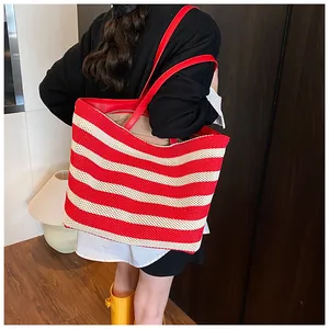 Gros plan du sac cabas tissé à rayures rouges et blanches avec anses en cuir synthétique