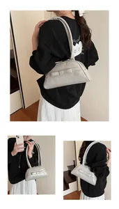 Detail view of cream white baguette shoulder bag with an elegant bow accent and long strap
