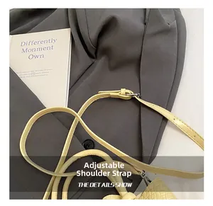 Detail of adjustable yellow crocodile texture shoulder strap with silver metal buckle