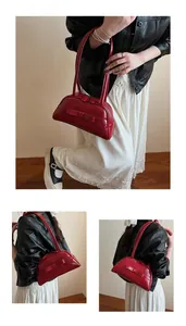 Detail of red patent leather bowling bag with bow and long dual shoulder straps