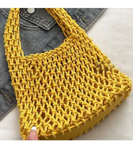 Detail of lemon yellow crochet knit tote bag showing intricate hollow mesh texture