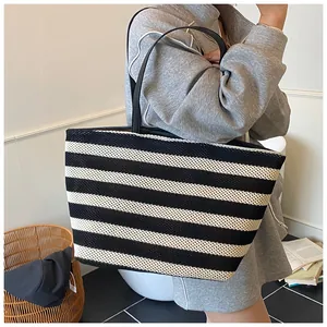 Gros plan d'un grand sac cabas tissé à rayures noires et blanches avec fines anses