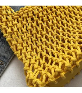 Close-up of bright yellow hollow knit handbag featuring premium handmade mesh texture