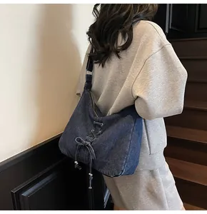 Détail du grand sac cabas en jean avec laçage décoratif croisé et œillets métalliques