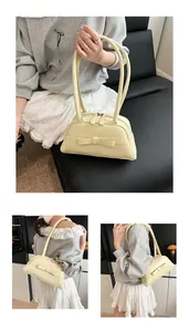 Detail showing pale yellow bow handbag with fine PU leather texture and dual zip closure