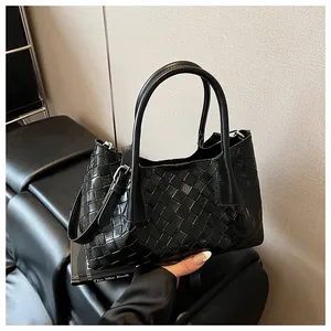 Détail du sac cabas tressé noir avec bandoulière réglable et doubles poignées