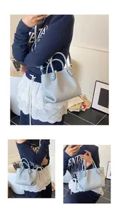 Detail of light blue woven leather bucket bag featuring knot handle and crossbody strap