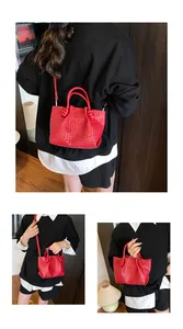 Detail of red woven leather bucket bag with circular handles and knotted accents
