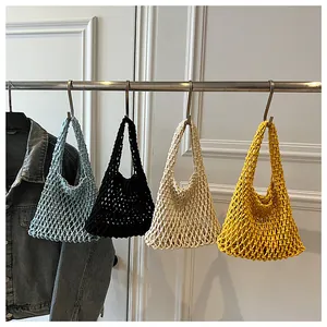 Detail showing four vibrant colors of hollow knit tote bags hanging on a rack
