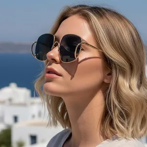 Lunettes de soleil à monture dorée et verres foncés avec vue sur la mer bleue