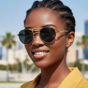 Lunettes de soleil aviateur en métal doré avec verres polarisés sombres sur modèle