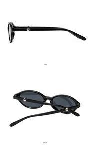 Detail view of oval cat-eye sunglasses with silver metal rivets on black frames