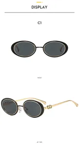 Detail view of oval sunglasses with gold metal hinges and sleek black frames