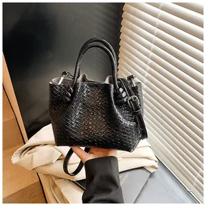 Close-up of black woven leather bucket bag with top handle and knotted detail finish
