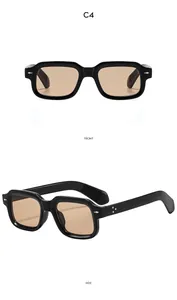 Detail of square black sunglasses with brown lenses and dual silver rivet accents
