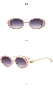 Detail view of oval pink sunglasses with golden metal temples and purple gradient lenses