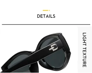 Macro side view of black cat-eye sunglasses with shiny frames and silver metal logo detail