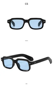 Macro detail of square black frame sunglasses with blue lenses and metal rivet accents