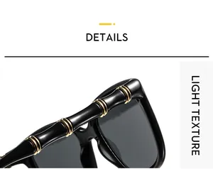 Detail of high-gloss black sunglasses featuring gold metal rings and bamboo-style frames