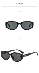 Detail view of black cat-eye sunglasses with gray lenses and metal G-shaped accents