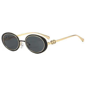Vintage oval sunglasses with black frames and gold metal temples on a white background