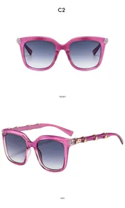 Detail view of purple oversized sunglasses featuring golden accents and bamboo-style legs