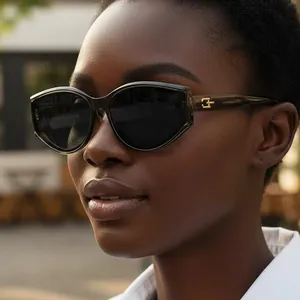 Retro cat-eye sunglasses with olive green frame and dark lenses on a female model
