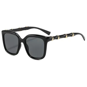 Retro oversized square sunglasses with black frame and golden bamboo-style metal temples