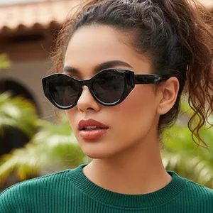 Retro Y2K cat-eye sunglasses with thick black frames and dark lenses for outdoor street style