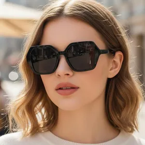 Lunettes de soleil hexagonales surdimensionnées à monture noire et verres foncés
